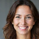 Porträt einer lächelnden Frau, die Selbstvertrauen ausstrahlt.